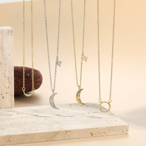 Detalle de los colgantes de luna creciente y estrella con circonitas en finas cadenas de oro