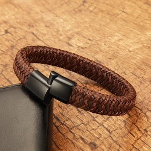Detail of hand-woven brown leather cord bracelet with black magnetic clasp on wood