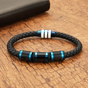 Close-up of blue and black woven leather bracelet with magnetic clasp on wood surface