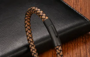 Dettaglio macro del cinturino in pelle marrone intrecciata e chiusura magnetica nera opaca