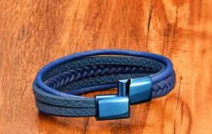 Close-up of multilayer braided leather bracelet with blue magnetic clasp on wood surface