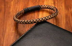 Dettaglio del bracciale in pelle intrecciata da uomo con chiusura magnetica in metallo nero
