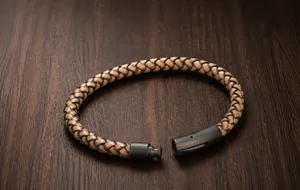 Dettaglio macro del cordino in pelle intrecciata marrone e chiusura magnetica in metallo