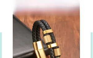 Detail of black woven leather bracelet with gold magnetic clasp and knurled beads