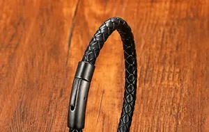 Dettaglio del bracciale in pelle intrecciata nera con chiusura magnetica in metallo nero