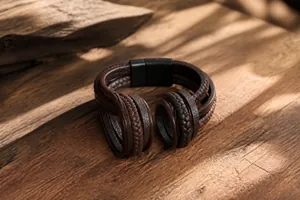 Close-up of brown braided leather strap and vintage texture on men's steel bracelet