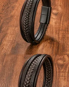 Close-up of multi-layer black braided leather bracelet with stainless steel clasp on wood