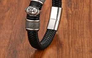 Dettaglio del bracciale in pelle nera intrecciata con testa di Buddha e chiusura
