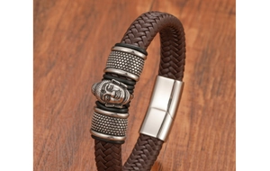 Dettaglio macro del bracciale in pelle intrecciata con testa di Buddha e chiusura in acciaio