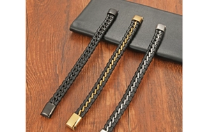 Detail of men's leather bracelets with steel clasps in black, gold, and silver finishes