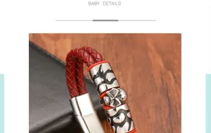 Detail of red braided leather bracelet featuring carved skull metal ornaments and clasp