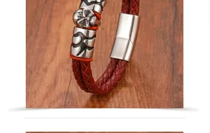 Macro view of men's red braided leather bracelet with silver skull and metal magnetic clasp
