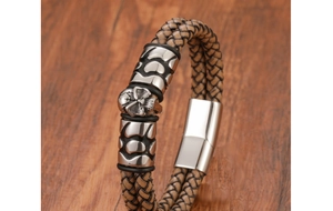 Detail of multi-layer braided leather bracelet with carved metal skull and magnetic clasp