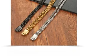 Dettaglio di catene hip hop intrecciate in acciaio inossidabile nelle finiture nero, oro e argento