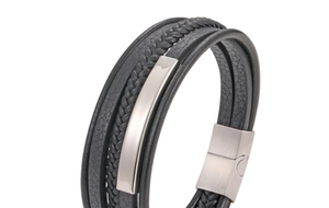 Detail of multi-layer black leather bracelet featuring braided cords and magnetic clasp