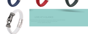 Detail of woven leather bracelet featuring an embossed silver fish motif on the white strap