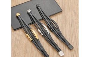 Three men's multilayer braided leather bracelets in gold, silver and black on wood background