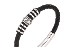 Macro shot of black braided leather bracelet with silver scroll beads and metal clasp