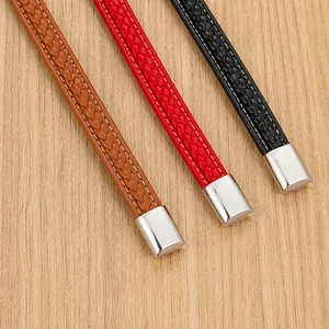 Detail of woven leather bracelets in brown, red, and black with polished steel clasps