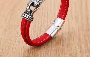 Detail shot of red braided leather bracelet showing silver clasp and ornate engravings