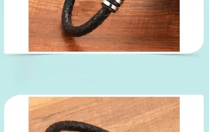 Detail showing the intricate woven black leather texture and silver metal clasp on the bracelet