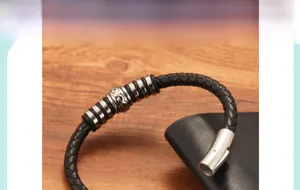 Detail of black braided leather bracelet with silver beads and magnetic metal clasp