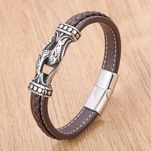 Braided brown leather bracelet with vintage silver metal charm and white stitching accents
