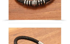 Macro shot of black braided leather bracelet with engraved silver beads on wood background