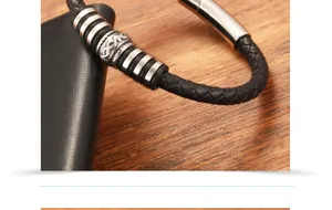 Close-up of braided black leather bracelet with vintage engraved silver metal beads