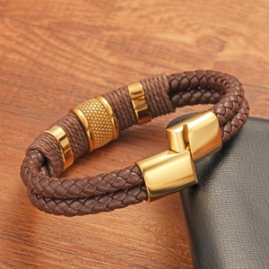 Macro detail of men's double braided leather bracelet with golden magnetic clasp