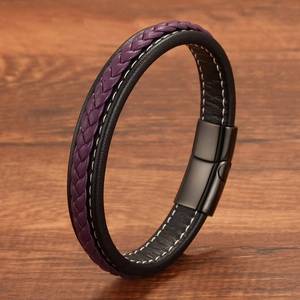 Detail of woven purple leather bracelet with black matte magnetic clasp on wood