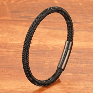 Bracelet tressé en acier inoxydable noir avec fermoir cylindrique sur support bois