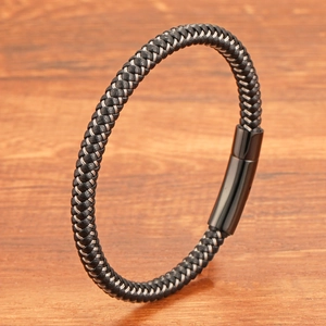Bracelet tressé minimaliste en acier inoxydable noir pour homme sur table en bois