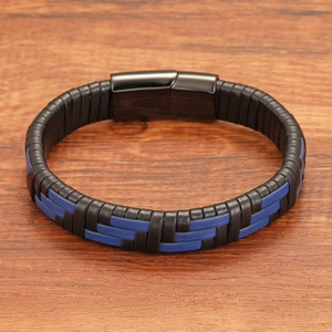 Detail of multi-layer woven leather punk bracelet with magnetic clasp on wood surface