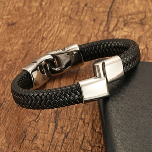 Bracelet pour homme en cuir tressé noir avec fermoir en acier inoxydable sur fond en bois