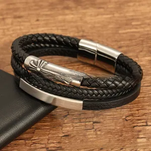 Detail of black multilayer braided leather bracelet with silver cross engraved metal bead