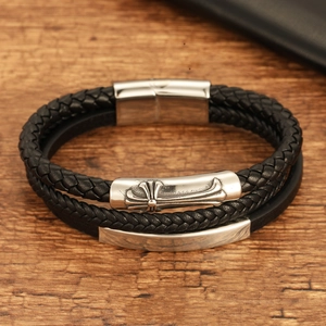 Mens double layered braided leather bracelet with vintage steel cross on wood background