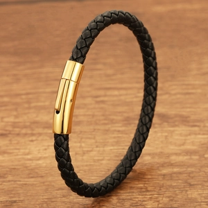 Close-up of black braided leather bracelet with a polished gold-toned metal magnetic clasp