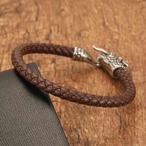 Close-up of vintage titanium steel dragon head clasp on brown braided leather bracelet