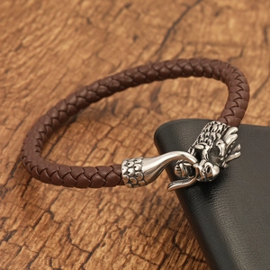 Detailed close-up of retro dragon head clasp on brown braided leather bracelet for men