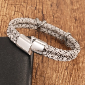 Detail of woven white leather bracelet with silver magnetic clasp and retro metal accents