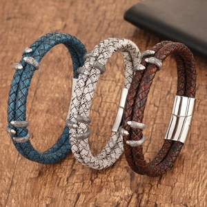 Detail of woven leather bracelets with silver dragon claw charms and magnetic clasp