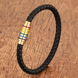 Braided black leather bracelet with rainbow magnetic clasp on a rustic wood background