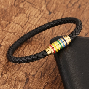 Detailed close-up of rainbow magnetic clasp and black braided leather bracelet on wood