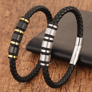 Detail of woven leather bracelets with knurled stainless steel beads on wood texture