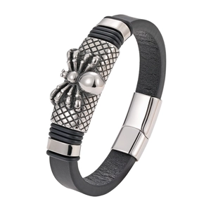 Macro detail of men's leather bracelet featuring a silver spider charm and metal clasp