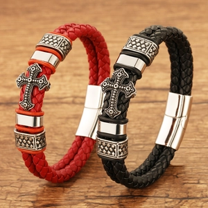 Detail of red and black woven leather bracelets with engraved metal cross magnetic clasp