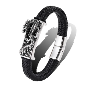 Macro shot of a braided black leather bracelet featuring an engraved silver dragon emblem