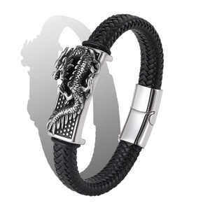 Close-up of braided black leather bracelet with silver dragon metal charm and magnetic clasp