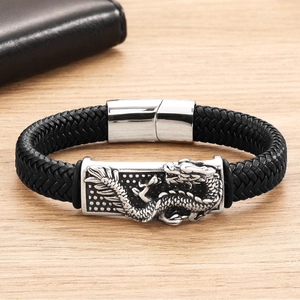 Men's braided black leather bracelet featuring a silver dragon relief on wood background